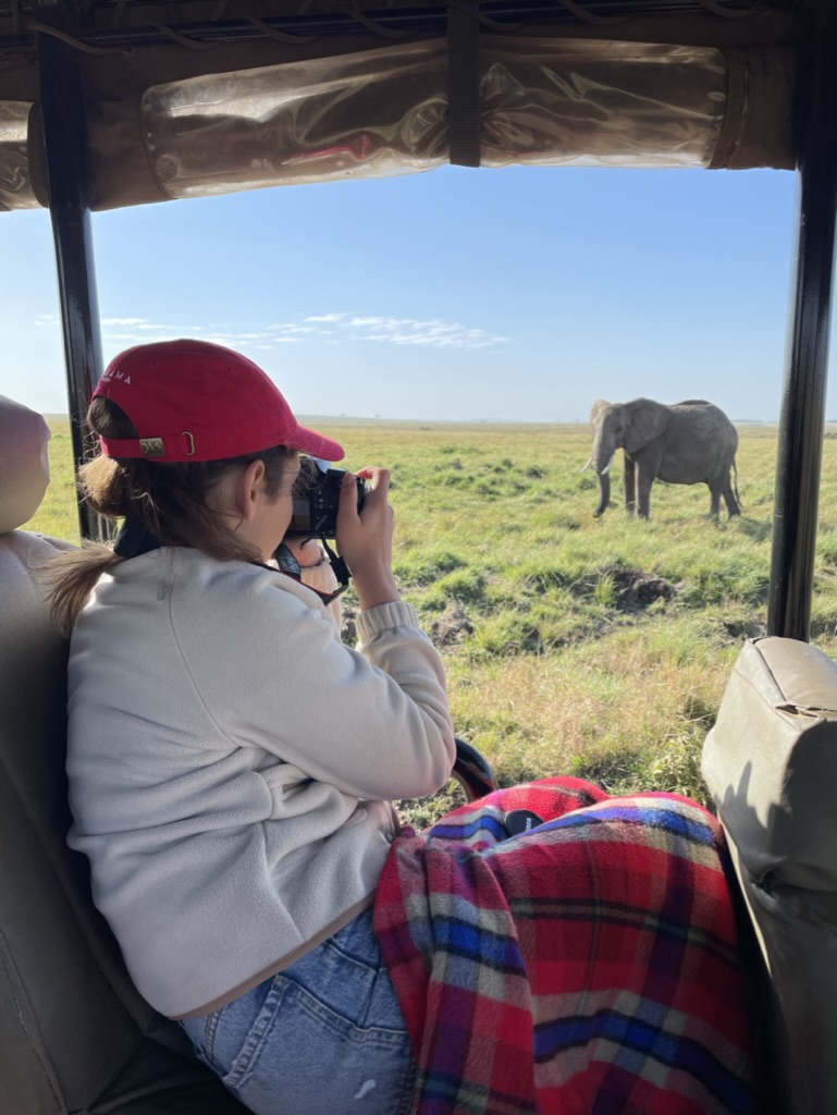 Young person photographing an elephant on safari in Kenya